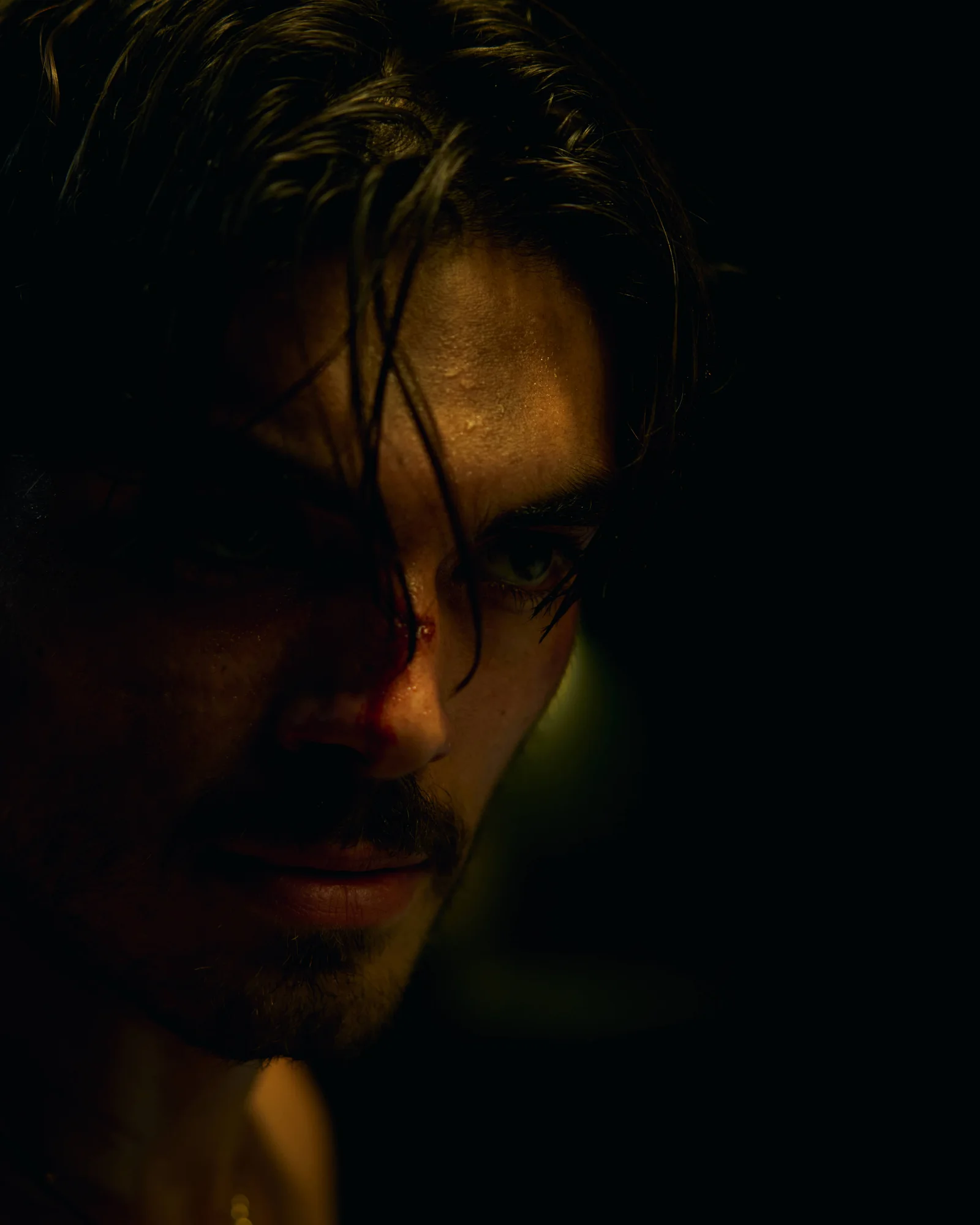 An actor on the warehouse set with dark cinematic lighting. The Hitman’s Dalliance.