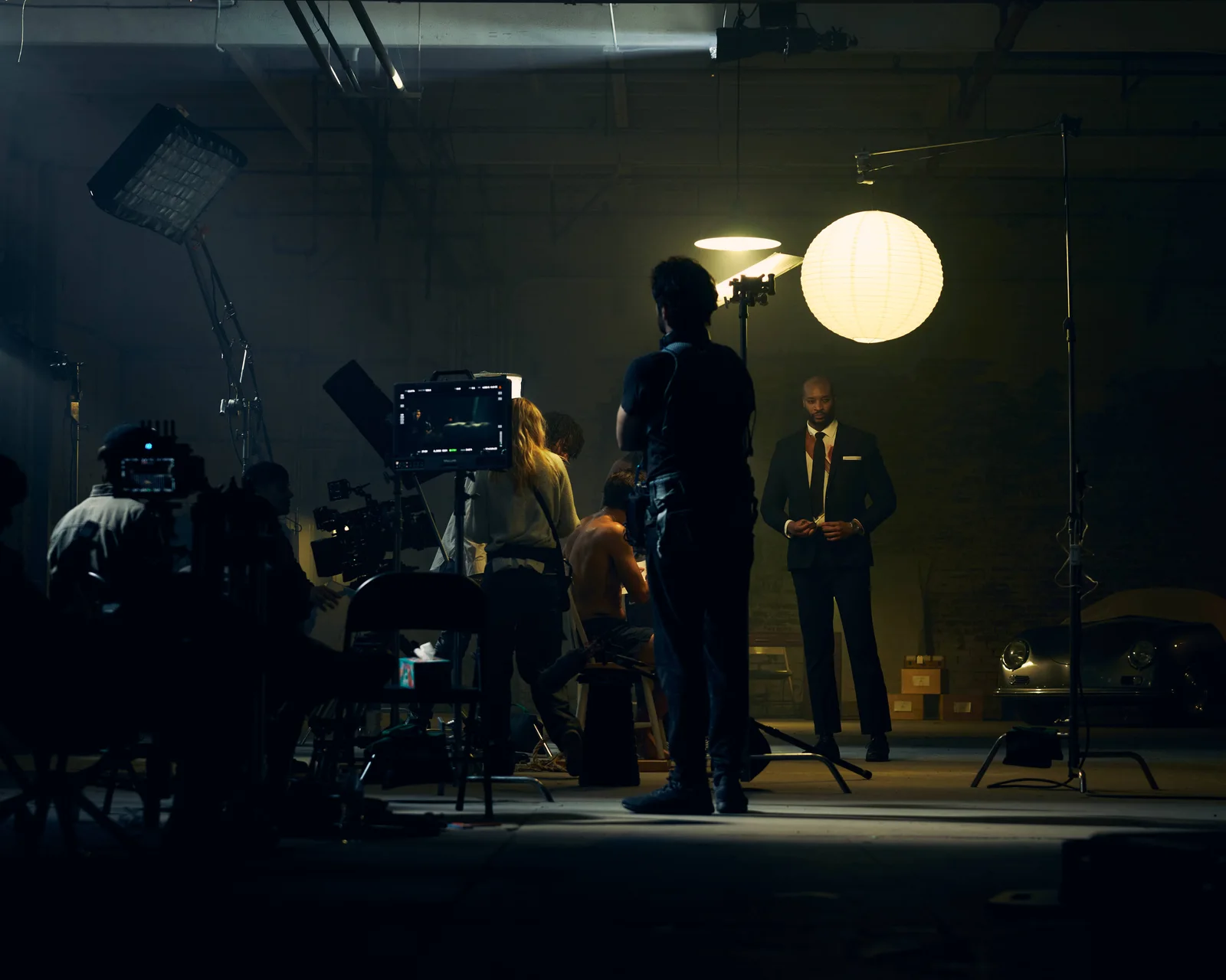 The camera crew, actors and a round practical light on the warehouse set. The Hitman’s Dalliance.
